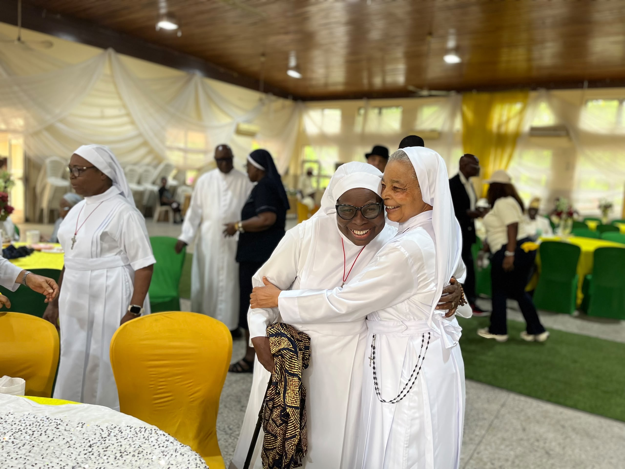 Elderly religious sisters sharing a warm embrace